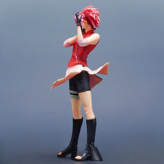 Action figure di Sakura Haruno, guerriera kunoichi di Konoha, in posa dinamica, dettagliata e colorata.