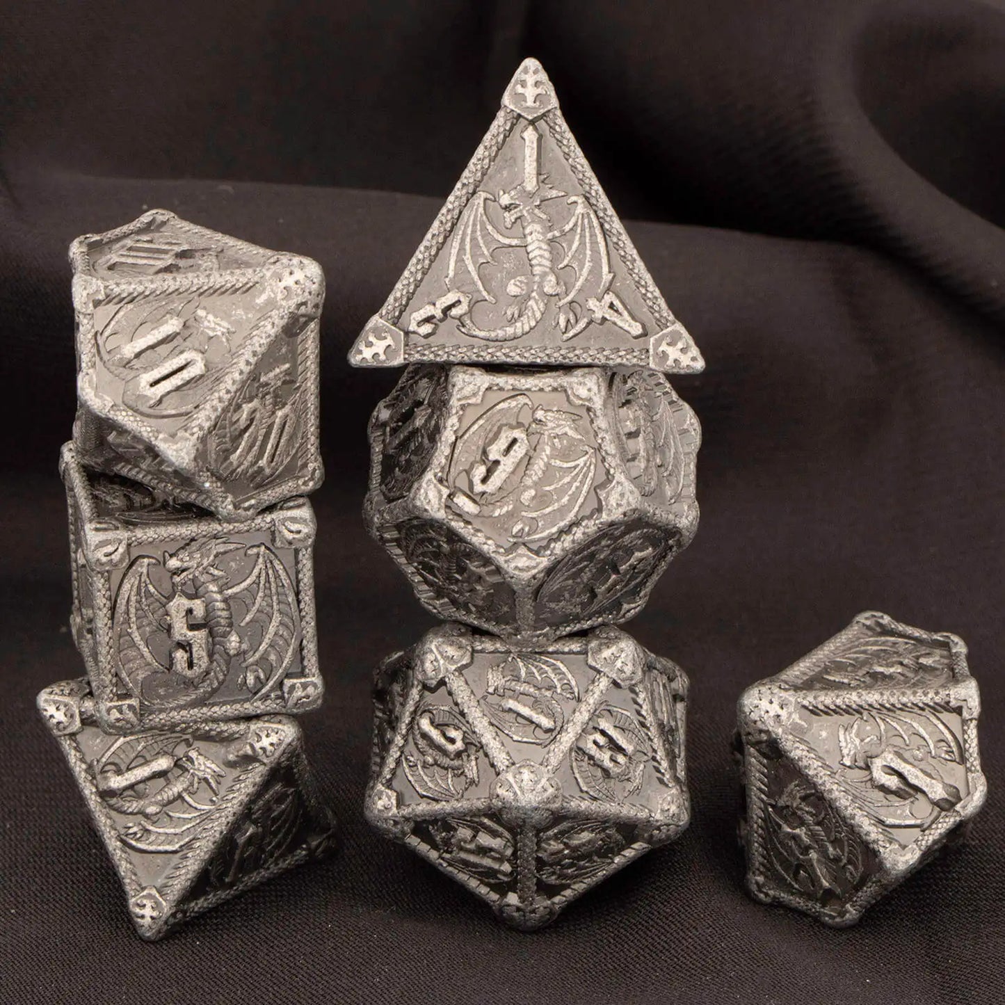 Set di 7 dadi poliedrici in metallo per giochi di ruolo Dungeons & Dragons, con numeri incisi, in vari colori metallici.